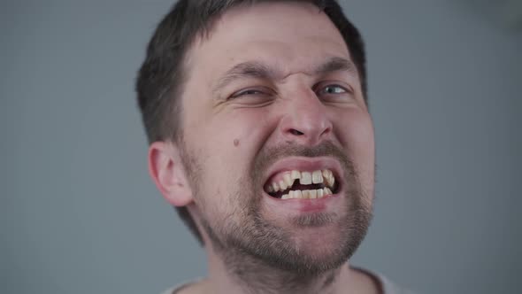 Caucasian Man Looks Disapprovingly at Old Worn Out Toothbrush As It is Time to Buy New One