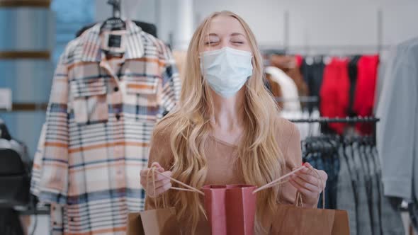 Blonde Girl with Long Hair Client Buyer Caucasian Woman in Medical Mask in Clothing Store with