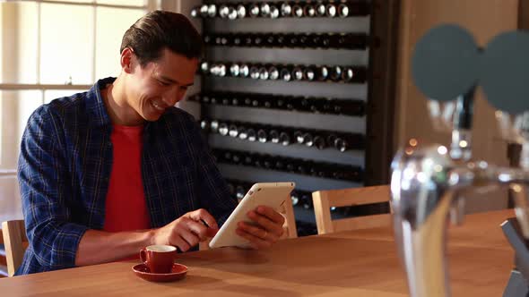 Man using digital tablet while having coffee in restaurant 4k