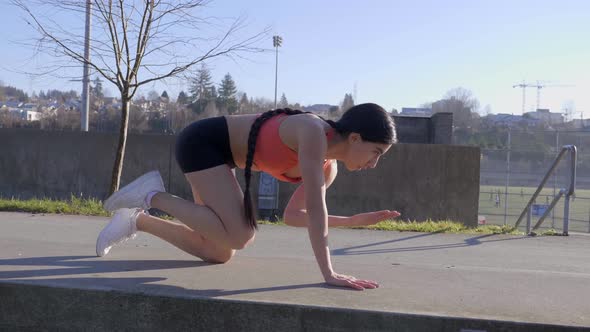 Plank pose one arm leg lift young athletic girl exercising outdoor