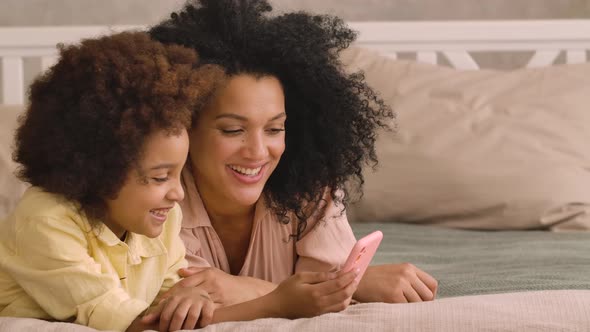 African American Woman and Litle Girl Talking on Video Call Using Smartphone