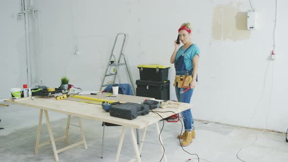 Cheerful Female Carpenter Talking on Smartphone