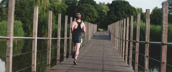 Man runs across a wooden bridge