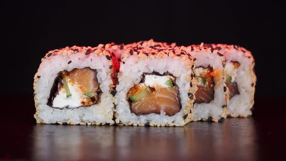 Sushi Rolls Rotate on Black Background. Close-up Shoot. Philadelphia Cheese and Salmon in Japanese