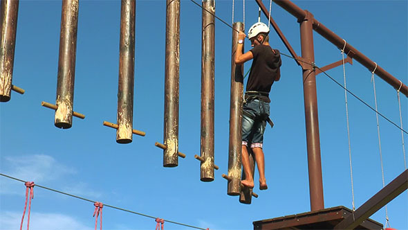 Man Goes on Beam that are Hanging on the Ropes