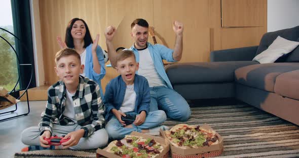 Satisfied Family which Celebrating Victory in Video Game and Raised Hands Up