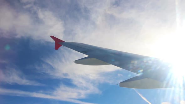Wing Of Flying Airplane And Sun Shining