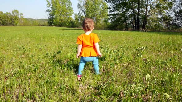 Baby First Steps On Green Lawn