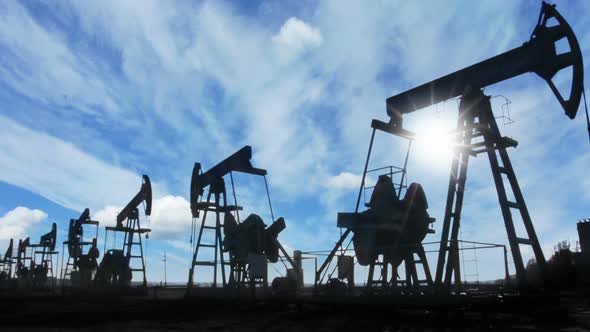 Working Oil Pumps Silhouette Against  Clouds 2 alt