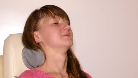 Young Woman Massaged Into Modern Automatic Massage Chair 2