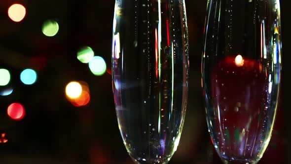 Glasses  Champagne And Candle Against Festive Lights Background