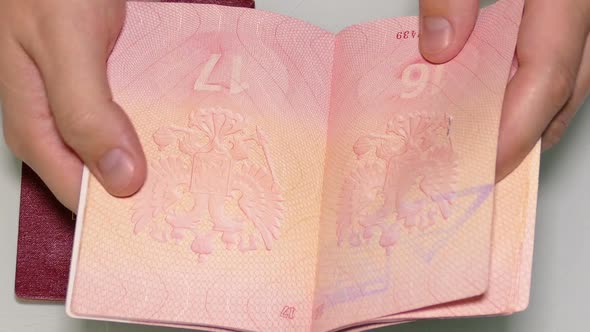 Man's Hands Turning The Pages Of The Passports  Visas And Stamps