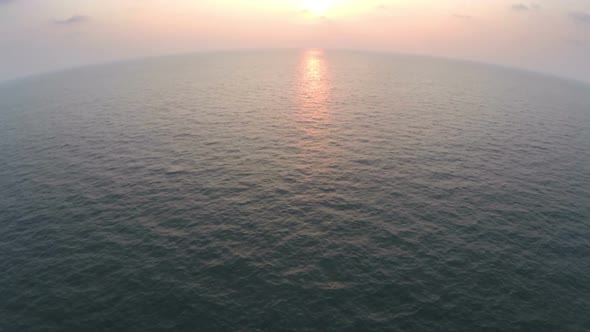 Flying From Beach Resort Over Endless Sea At Sunset