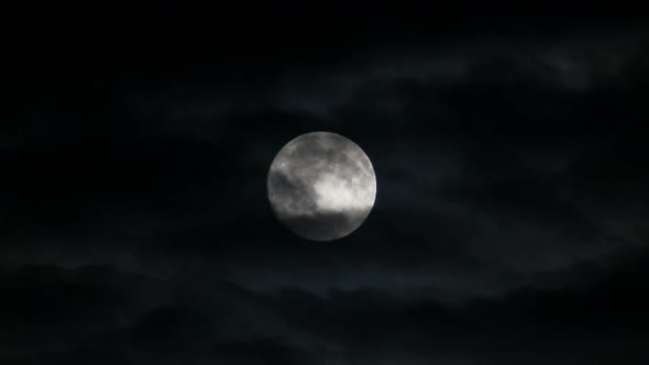 Full Moon Moving Between Clouds alt