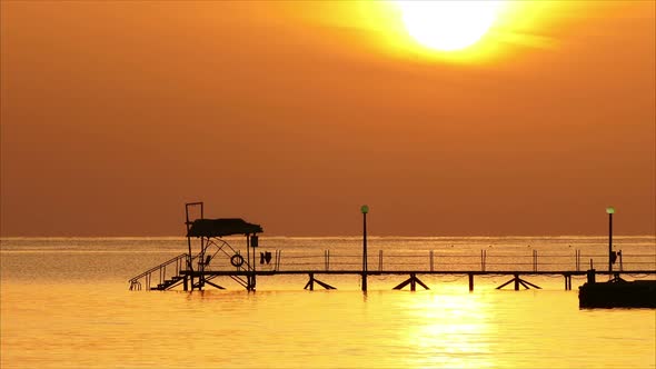 Beautiful Sunrise Over Pier In Sea - Filmed At Telephoto Lens,