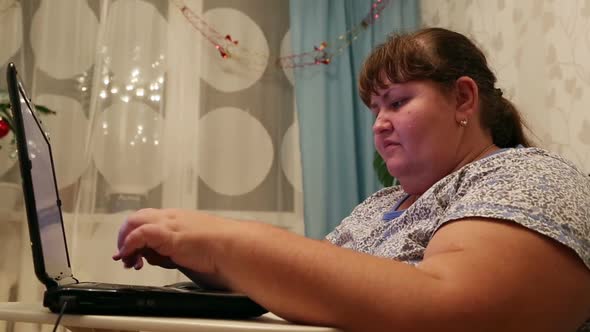 Overweight Woman Typing On Computer At Home alt