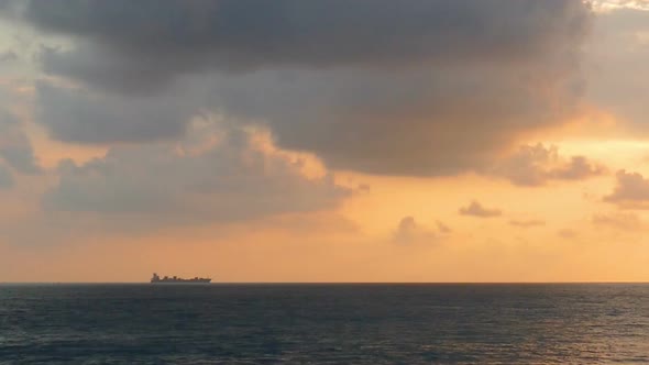 Ship On Horizon Of Sea At Sunset -