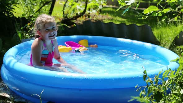 Cheerful Girl In Inflatable Pool In Summer Garden 4 alt
