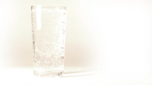 Mineral Water Is Poured Into A Glass On White Background -