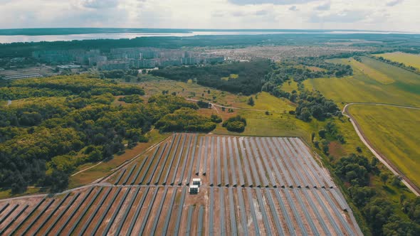 Aerial View on Solar Power Station in Green Field Near Small City at Sunny Day