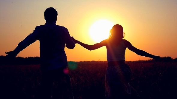 Silhouette Of Happy Couple Join Hands Runs Across