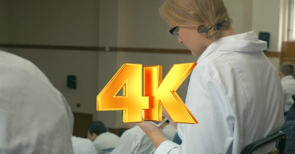 Medical Student Taking Notes On Pad During Lecture alt