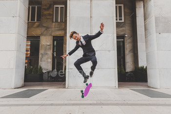 Young handsome Asian model jumping with his skateboard