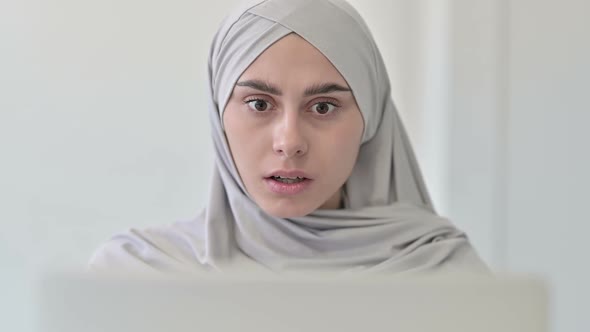 Arab Woman with Laptop Reacting to Loss