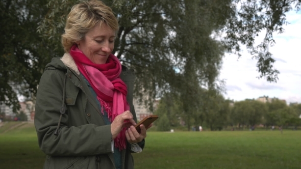 Adult Woman Using Smartphone In The Park