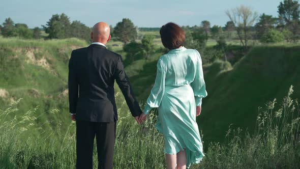 Back View Loving Happy Man and Woman Holding Hands Admiring Beauty of Spring Summer Nature