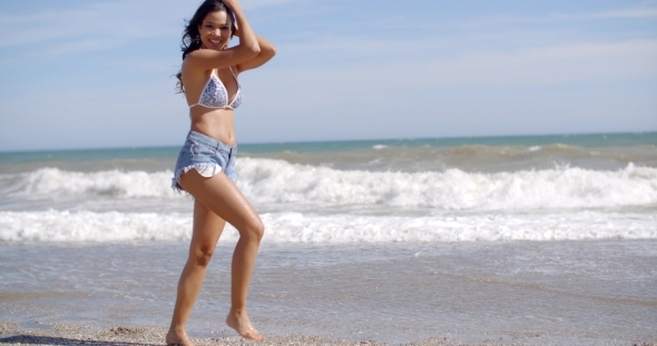 Young Woman Walking Along The Surf