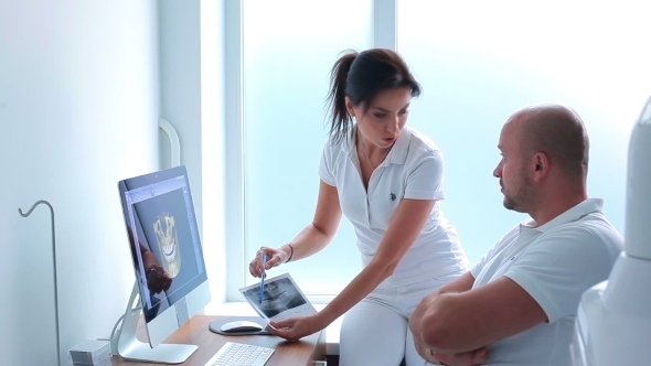 Two Dentists Discussing The X-ray Photograph alt