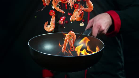 Super Slow Motion Shot of Chef Holding Frying Pan and Falling Shrimps Into Fire at 1000Fps.