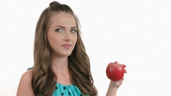 Thoughtful Young Woman Eating a Dark Red Apple On alt