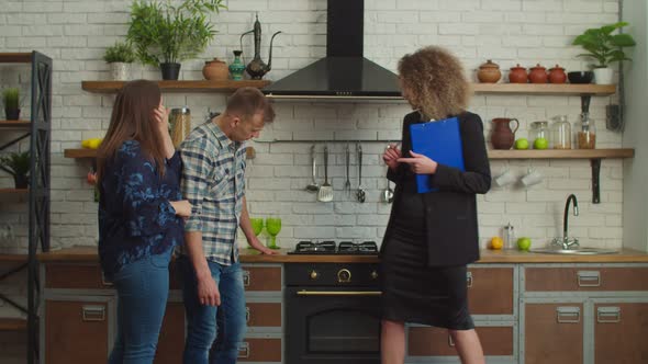 Lovely Female Real Estate Agent Showing New Apartment to Married Couple