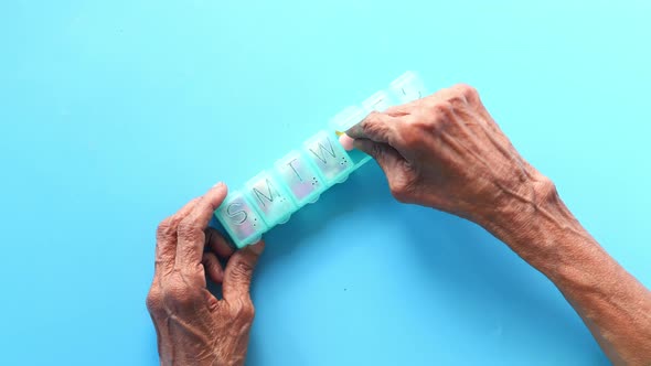 Senior Women Hand's Taking Medicine From a Pill Box