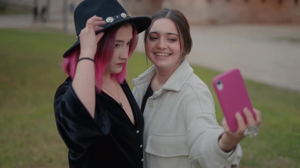 Stylish Girl Friends Making Kissing Lips While Taking Selfie Outdoors