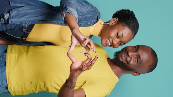 Vertical Video People in Love Advertising Heart Shape Sign with Hands in Front of Camera