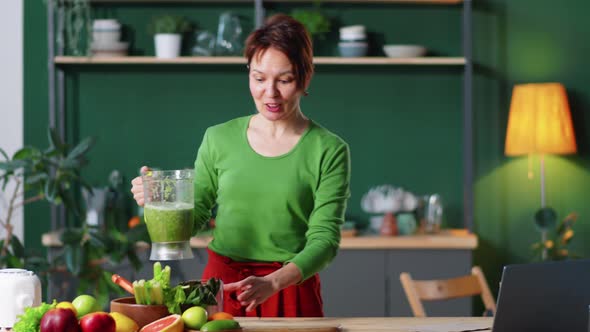 Woman Telling about Green Smoothie at Camera