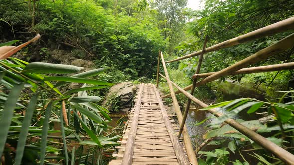 Walking at Bamboo Bridge Over the River in Tropical Rainforest Jungle. Slowmotion Wide Angle POV