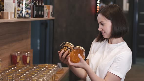 Female Customer Choosing Oney in a Jar at the Store