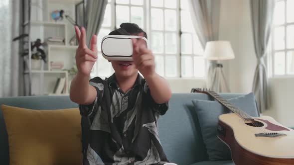 Asian Boy Playing Video Game While Wearing VR Glasses Headset