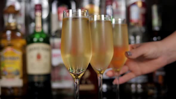 Closeup of a Woman Taking a Glass of Cold Champagne in a Bar