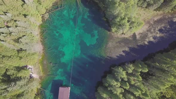 Aerial drone shot flying over crystal blue water of Kitch-iti-kipi, the big spring, in Palms Book St