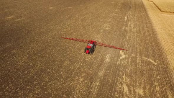 Tractor Sprays Which Protect Against Pests at a Farmer's Field Corn, Aerial Shot