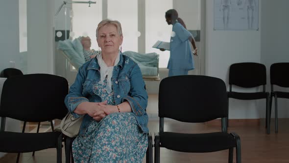 Portrait of Senior Patient Sitting in Waiting Room Area