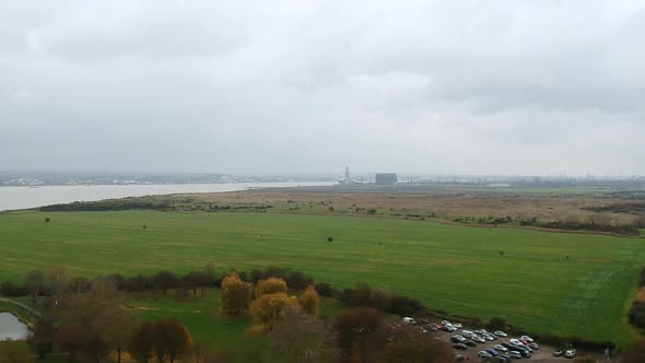 Coalhouse Fort Park in Essex on grey cloudy day with Thames and Tilbury docks in background.