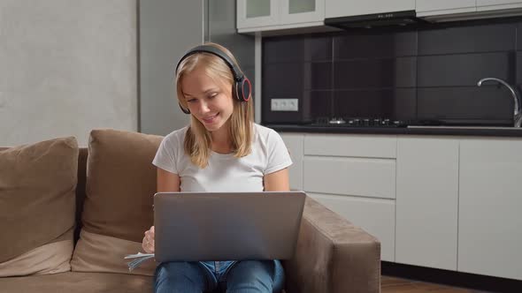 Young Woman in Headphones Having Online Studying on Laptop