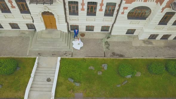 Bride Dances Near Groom at Building on Street Bird Eye View