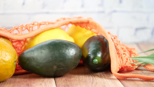 Fresh Orange Fruit and Avocado in a Shopping Bag on Table